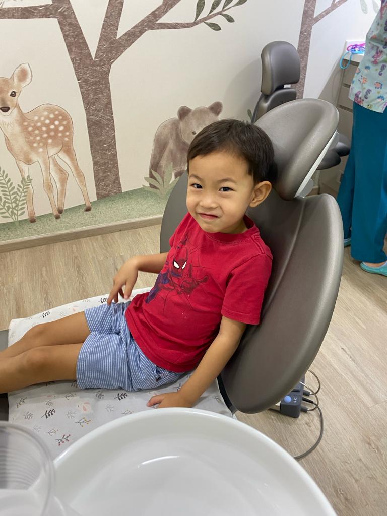 Happy child receiving dental checkup at just kids dental clinic singapore.