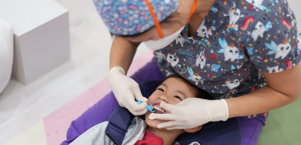 A child receiving dental care from a dentist at just kids pediatric dental clinic. Friendly dental care faq