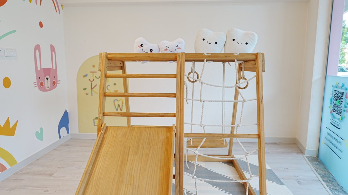 Wooden play equipment with plush tooth toys at just kids pediatric dental clinic.